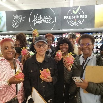 Group of women holding up a dragon fruit