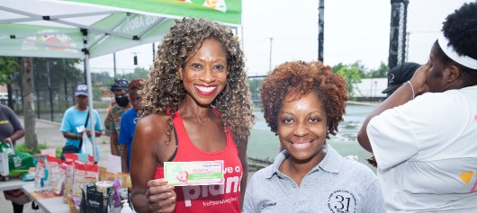 Elizabeth Madison with a sponsor holding a check