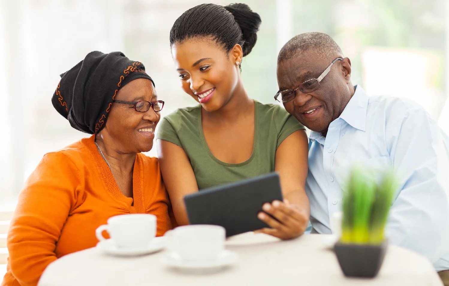 Young lady showing older parents a tablet