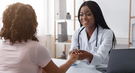 Young nurse holding a patients hand while smiling