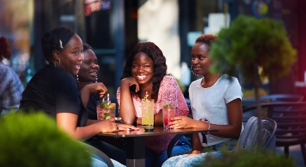 Young girls, having a cool drink, at an outdoor patio