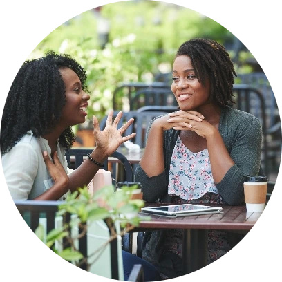 Two women gossiping over coffees
